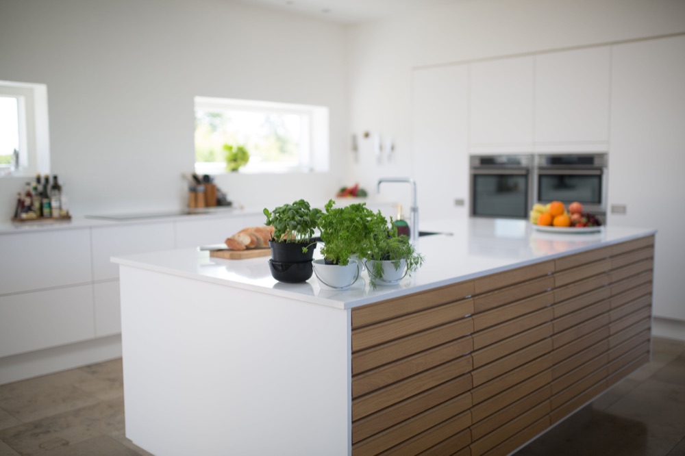 Cuisine moderne avec îlot central et plantes aromatiques